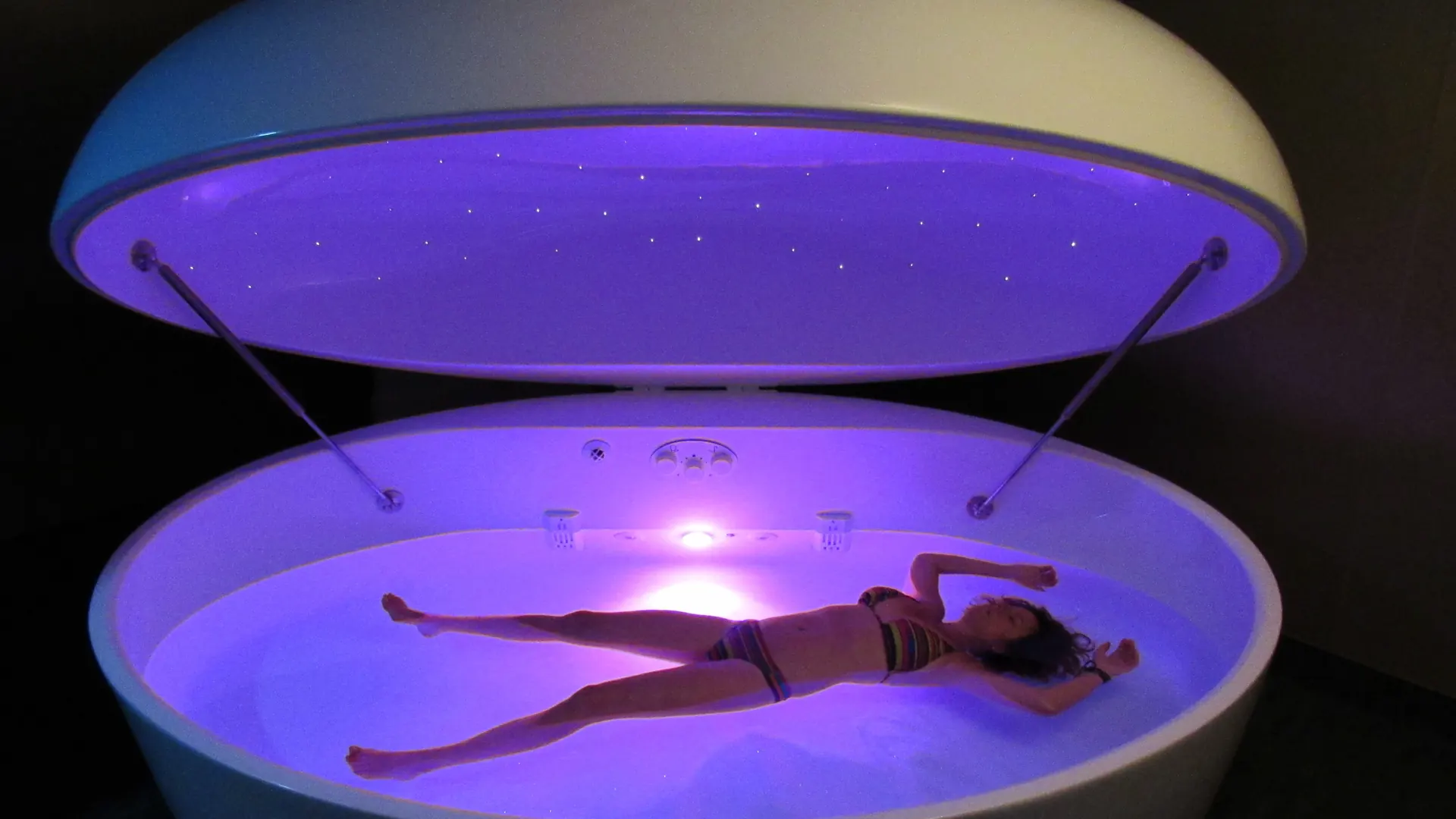 Open float pod glowing violet with a member floating inside