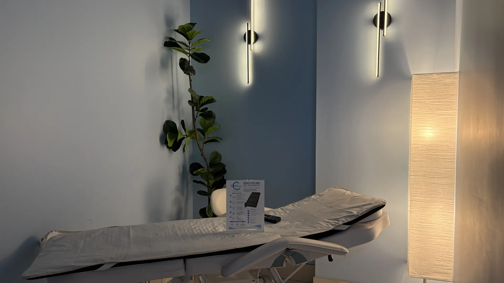 PEMF and infrared therapy table with warm sconce lighting at CHILL on Del Prado